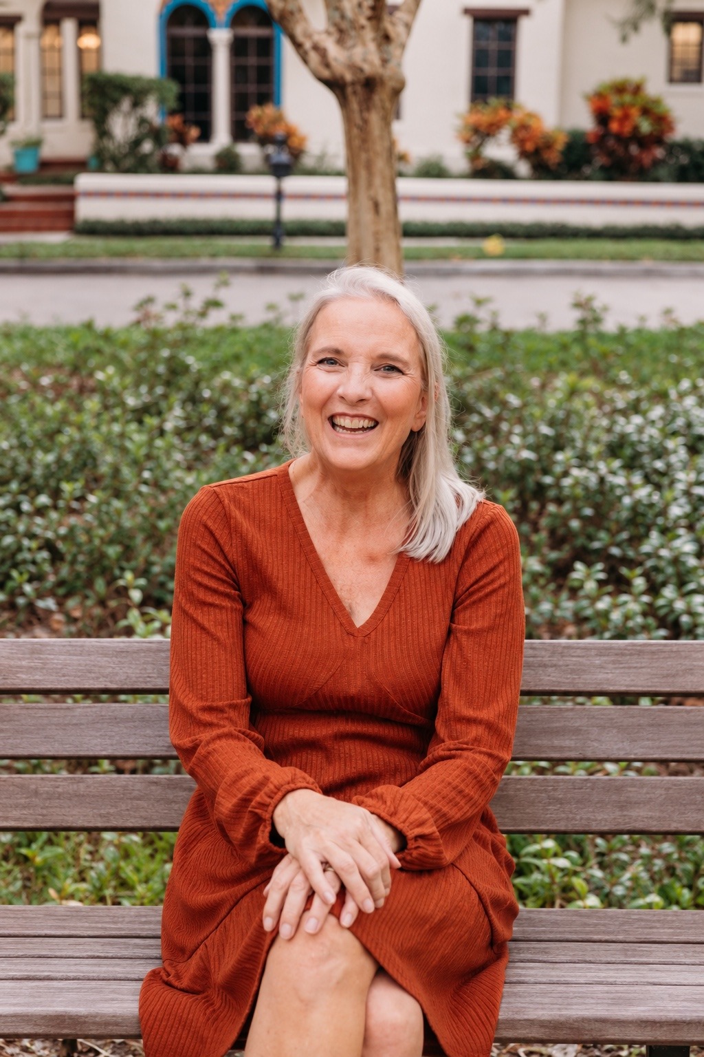 Edie smiling while seated on a park bench